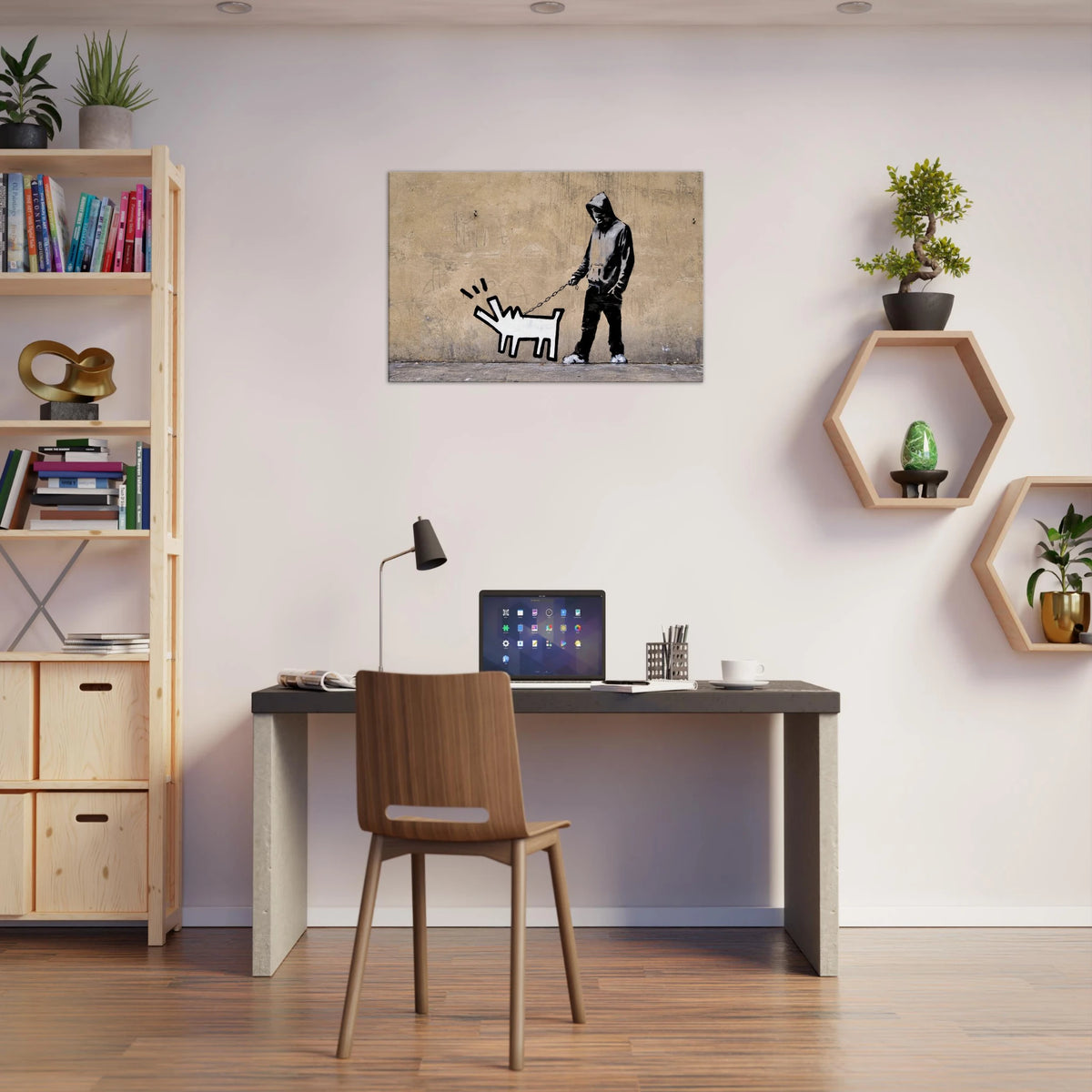 Banksy Choose Your Weapon canvas featuring Keith Haring's barking dog displayed above a desk in a creative workspace.