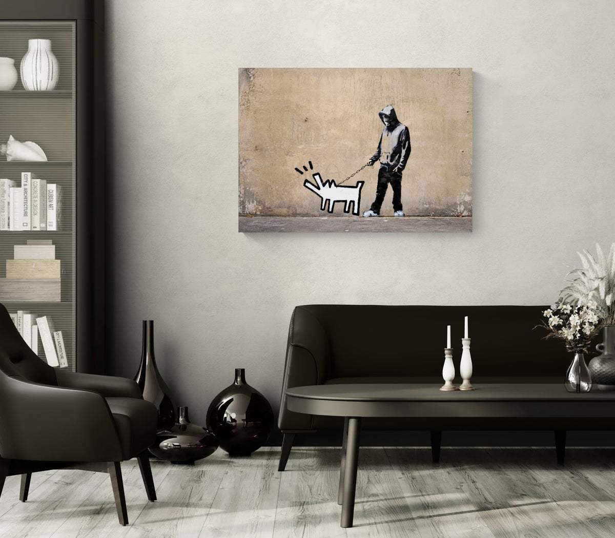 Banksy Choose Your Weapon canvas print displayed above black leather furniture in a contemporary living room with neutral walls.