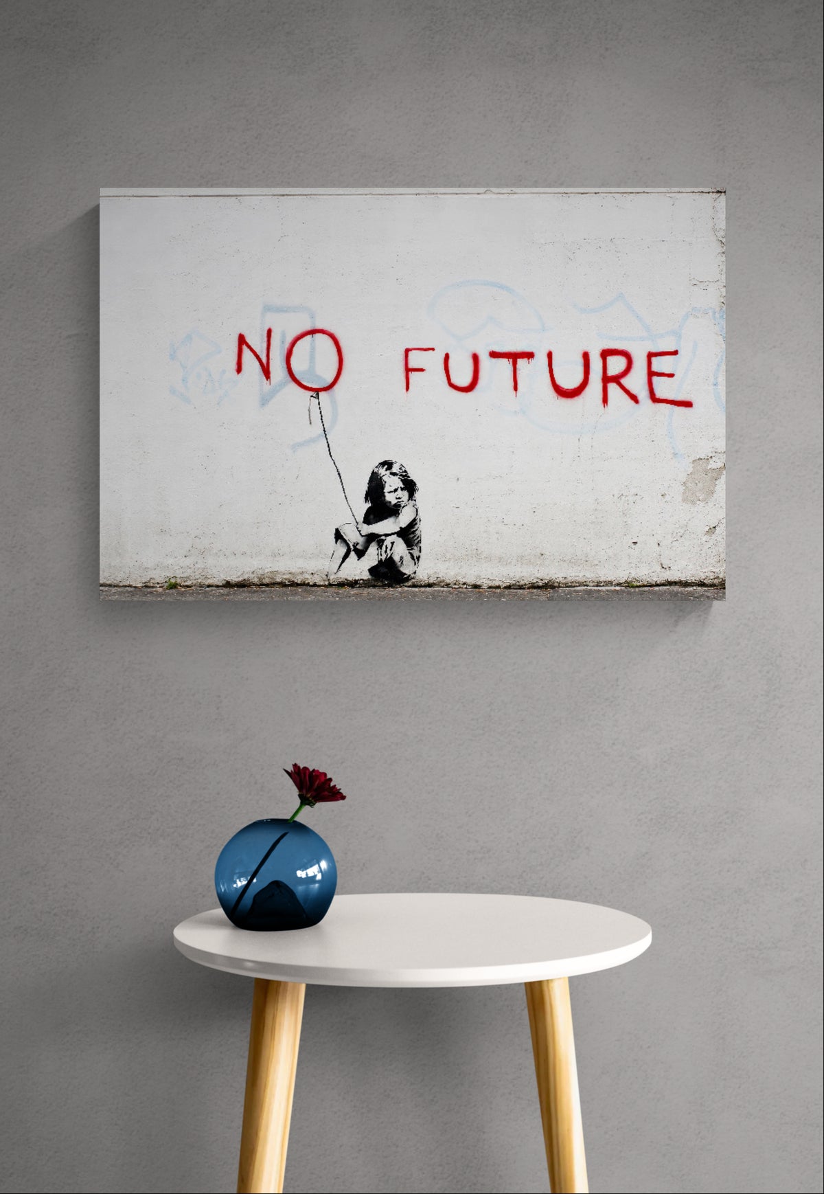 No Future graffiti canvas on a light grey wall above a small round side table with a blue decorative vase